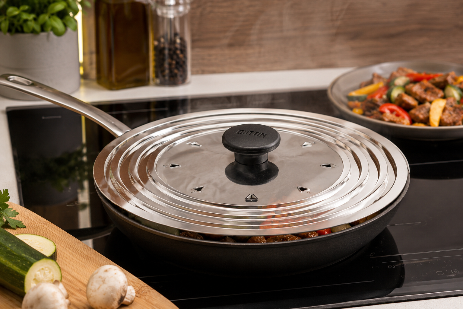 Quttin universeel spatdeksel naast koekenpan en braadpan in moderne keuken sfeerfoto