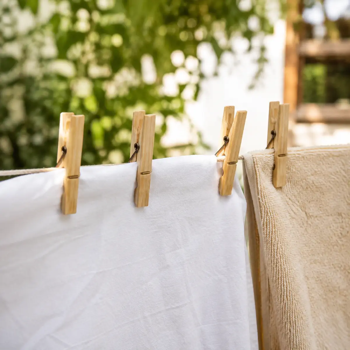 Bamboe wasknijpers aan waslijn met kleding en handdoek