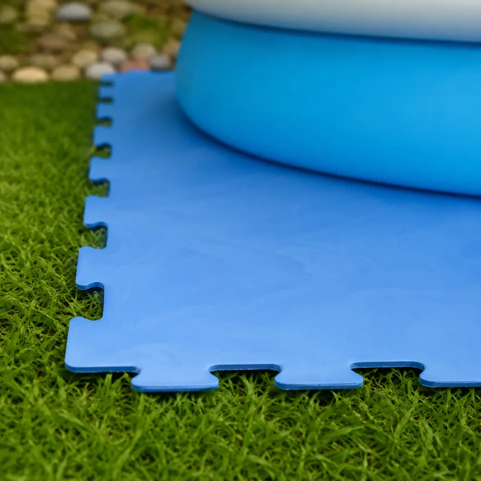 Blauwe zwembad vloerbeschermingsmat met puzzelrand op gras