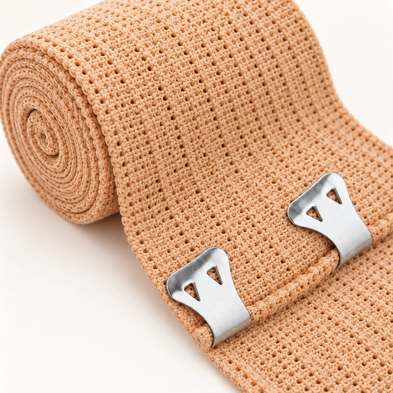Detail van de beige geweven bandage en de twee metalen bevestigingsklemmen